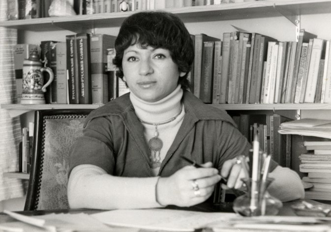 Anna Frajlich at her desk, surrounded by bookshelves